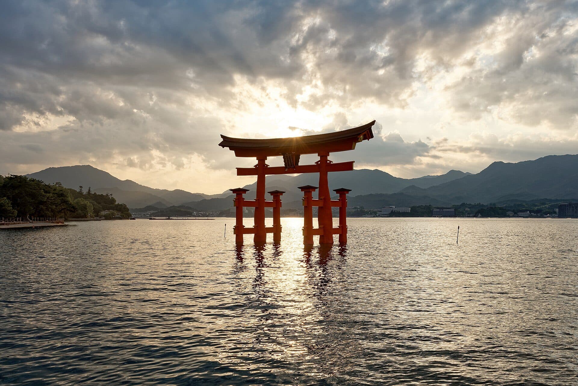 Brama torii sanktuarium Itsukushima stojąca w wodzie o zachodzie słońca